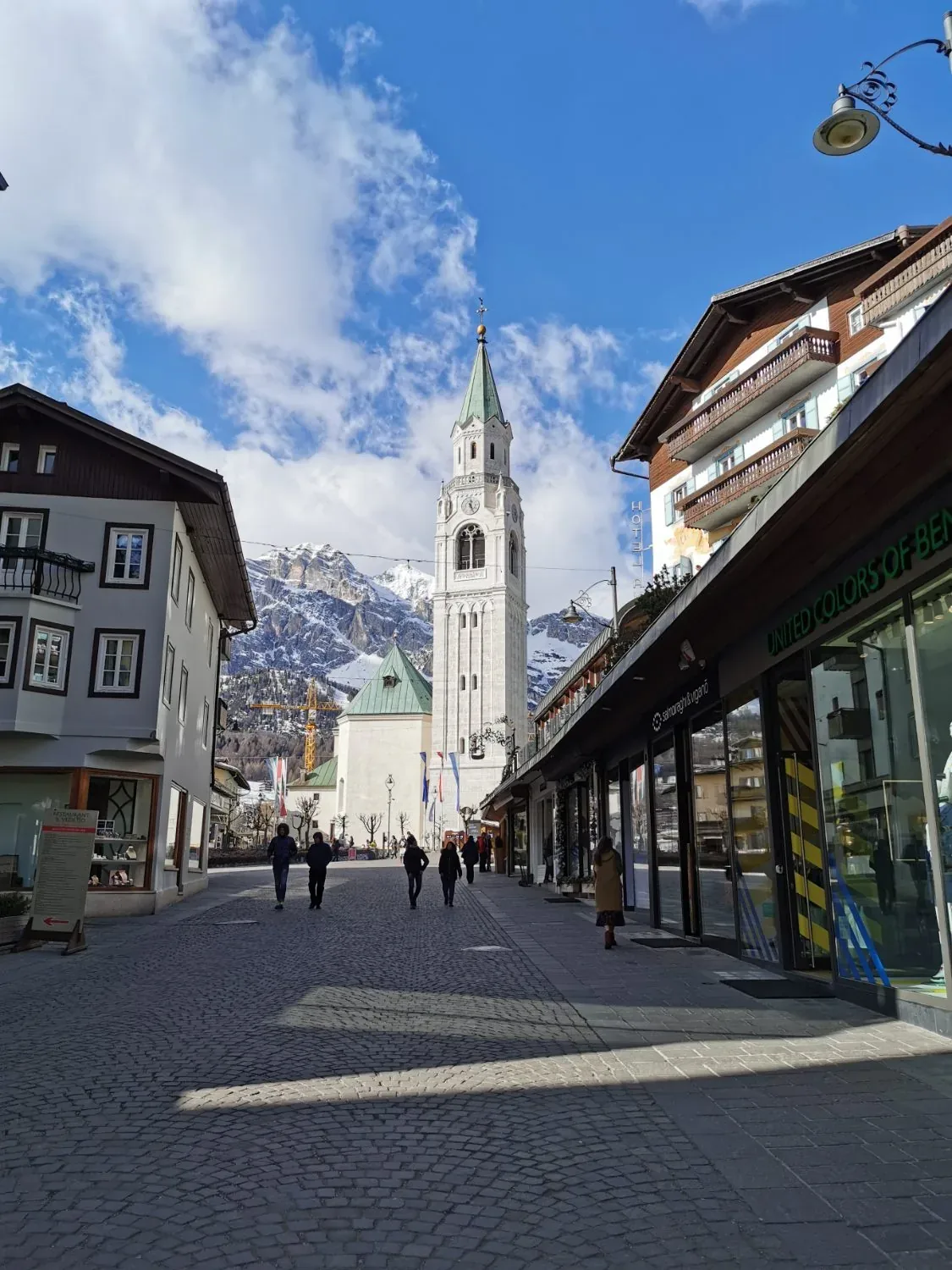 A quiet alpine town street beneath the Dolomites