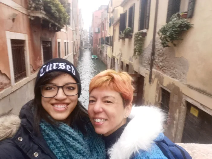 Two friends smiling above a Venice canal